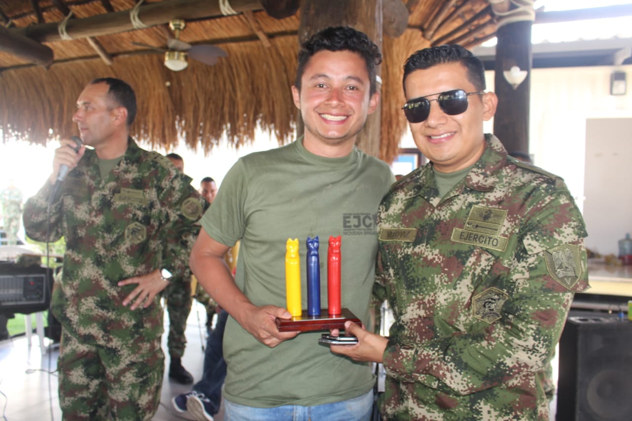 Periodista recibiendo premio de parte del teniente coronel Erwin Vitoviz.